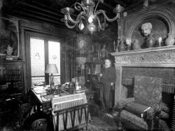 L'écrivain Anatole France chez lui debout près d'une cheminée