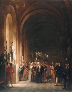 C’est la nuit, la famille d’Orléans (Louis-Philippe et Marie-Amélie au centre) est venue admirer la statue de Jeanne que des domestiques éclairent à l’aide de lampes à réflecteurs tenues à bout de bras au-dessus des têtes. 