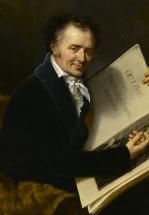 Un homme souriant assis tient un livre avec un dessin
